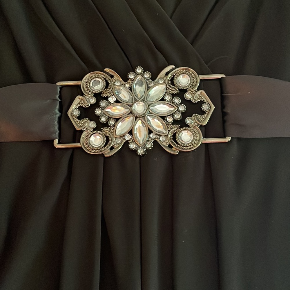 Black dress with silk ties at waist and jeweled pendant on front. - Picture 2 of 3